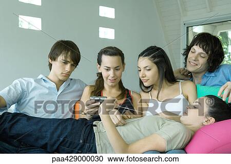 Teenage friends looking at digital camera together View Large Photo Image Stock Image - Teenage friends looking at digital camera together. Fotosearch