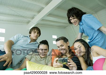 Teenage friends looking at digital camera together View Large Photo Image Stock Photo - Teenage friends looking at digital camera together. Fotosearch