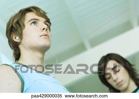 Teenage friends, one listening to earphones View Large Photo Image Stock Photography - Teenage friends, one listening to earphones . Fotosearch