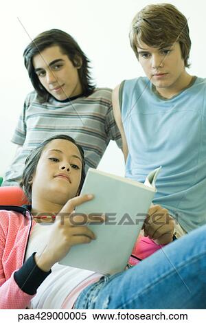 Stock Photography - Teenage friends, one reading book . Fotosearch