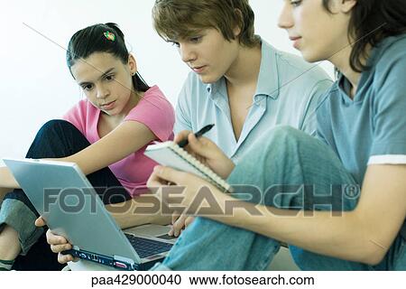 Teenage friends using laptop together View Large Photo Image Stock Image - Teenage friends using laptop together. Fotosearch