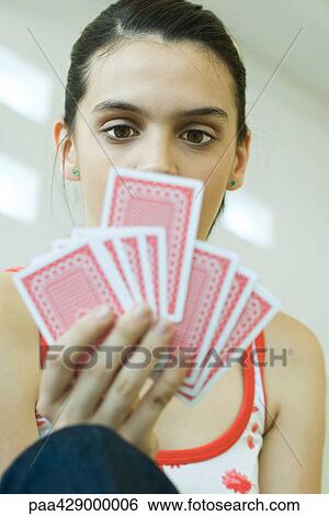 Stock Photograph - Teenage girl holding up hand of cards. Fotosearch