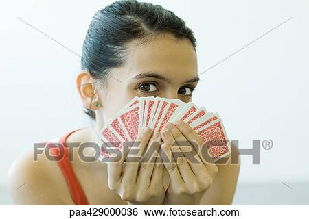 Teenage girl looking at camera over hand of cards View Large Photo Image Stock Photograph - Teenage girl looking at camera over hand of cards. Fotosearch