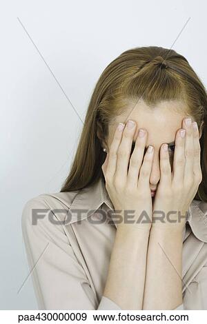 Stock Photo - Teenage girl, hands over face, portrait. Fotosearch