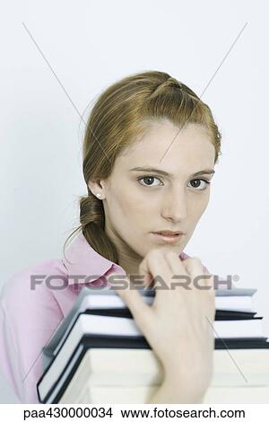 Picture - Teenage girl holding stack of books, portrait. Fotosearch