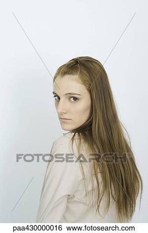 Teenage girl looking over shoulder at camera, portrait View Large Photo Image Stock Photograph - Teenage girl looking over shoulder at camera, portrait. Fotosearch