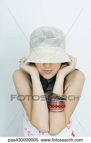 Stock Photography - Teenage girl pulling hat down over eyes, portrait. Fotosearch