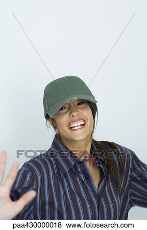 Teenage girl wearing cap, smiling, arms out, portrait View Large Photo Image Stock Photo - Teenage girl wearing cap, smiling, arms out, portrait. Fotosearch