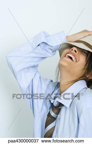 Stock Photo - Teenage girl wearing tie and hat, head back, smiling at camera, portrait. Fotosearch