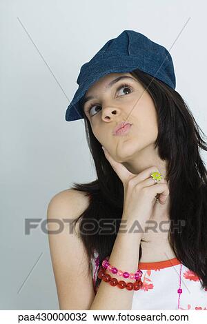 Teenage girl with finger on cheek, looking up, portrait View Large Photo Image Stock Image - Teenage girl with finger on cheek, looking up, portrait. Fotosearch