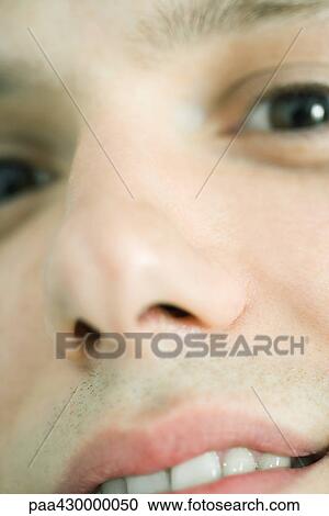 Stock Image - Young man, extreme close-up of face. Fotosearch