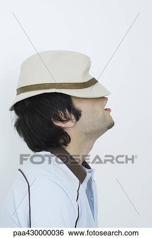 Young man wearing hat pulled down over eyes, side view View Large Photo Image Stock Photograph - Young man wearing hat pulled down over eyes, side view. Fotosearch