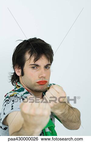 Young man wearing lipstick, holding out fists at camera View Large Photo Image Stock Photograph - Young man wearing lipstick, holding out fists at camera. Fotosearch