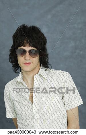 Young man wearing sunglasses, portrait View Large Photo Image Stock Image - Young man wearing sunglasses, portrait. Fotosearch