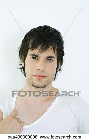 Young man wearing tee-shirt, pulling on collar, portrait View Large Photo Image Stock Photo - Young man wearing tee-shirt, pulling on collar, portrait. Fotosearch