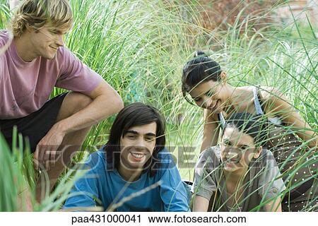 Group of young friends in tall grass View Large Photo Image Stock Image - Group of young friends in tall grass. Fotosearch