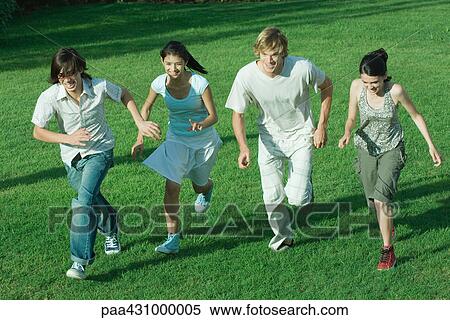 Group of young friends, running across grass together View Large Photo Image Stock Photography - Group of young friends, running across grass together. Fotosearch