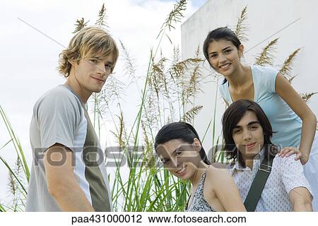 Group of young friends smiling at camera View Large Photo Image Stock Image - Group of young friends smiling at camera. Fotosearch