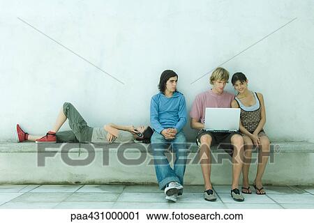Group of young friends using laptop together View Large Photo Image Stock Image - Group of young friends using laptop together. Fotosearch