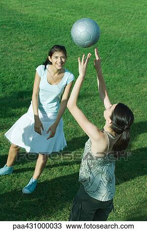 Two young female friends playing with soccer ball View Large Photo Image Stock Image - Two young female friends playing with soccer ball. Fotosearch
