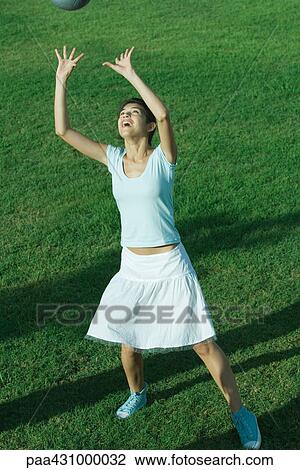 Young woman reaching for ball, full length View Large Photo Image Stock Image - Young woman reaching for ball, full length. Fotosearch