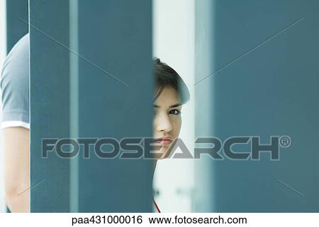 Young woman, seen through blurred foreground View Large Photo Image Stock Photograph - Young woman, seen through blurred foreground. Fotosearch