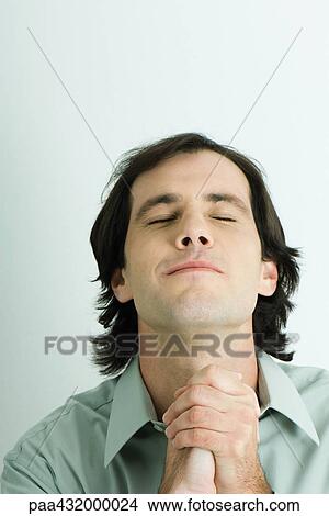 Man clasping hands, head back and eyes closed, head and shoulders, portrait View Large Photo Image Picture - Man clasping hands, head back and eyes closed, head and shoulders, portrait. Fotosearch