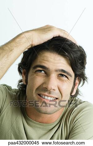 Stock Photography - Man holding head and looking up, head and shoulders, portrait. Fotosearch