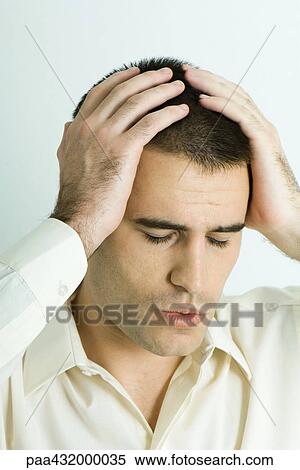 Stock Photography - Man holding head, eyes closed, head and shoulders, portrait. Fotosearch