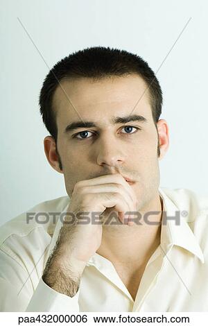 Man looking at camera, hand in front of mouth, head and shoulders, portrait View Large Photo Image Stock Photograph - Man looking at camera, hand in front of mouth, head and shoulders, portrait. Fotosearch