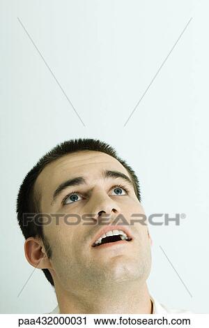 Stock Image - Man looking up, head back and mouth open, portrait. Fotosearch