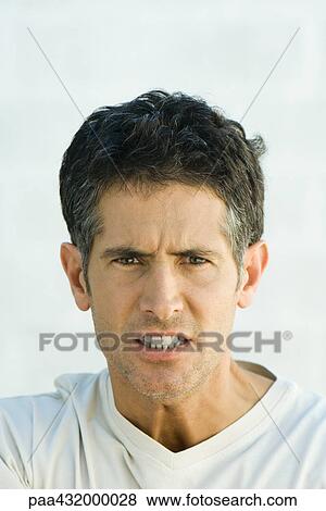 Man scowling at camera, head and shoulders, portrait View Large Photo Image Stock Photo - Man scowling at camera, head and shoulders, portrait. Fotosearch