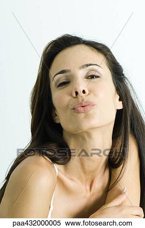 Stock Photography - Woman blowing kiss to camera, head and shoulders, portrait. Fotosearch