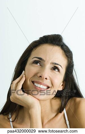 Woman holding head, looking up and smiling, head and shoulders, portrait View Large Photo Image Stock Photo - Woman holding head, looking up and smiling, head and shoulders, portrait. Fotosearch