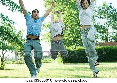 Stock Photograph - Family outdoors jumping in air on a sunny day. Fotosearch