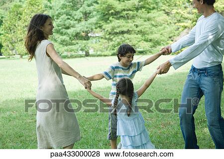 Family outdoors on lawn playing ring-around-the-rosy View Large Photo Image Stock Photo - Family outdoors on lawn playing ring-around-the-rosy. Fotosearch