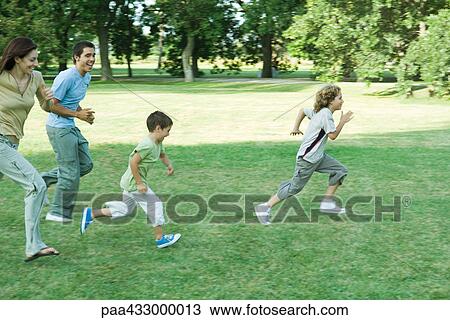 Family outdoors running across grassy lawn on a sunny day View Large Photo Image Stock Image - Family outdoors running across grassy lawn on a sunny day. Fotosearch
