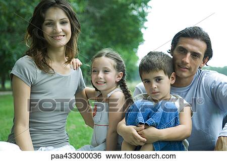 Stock Photograph - Family outdoors, smiling at camera, portrait. Fotosearch
