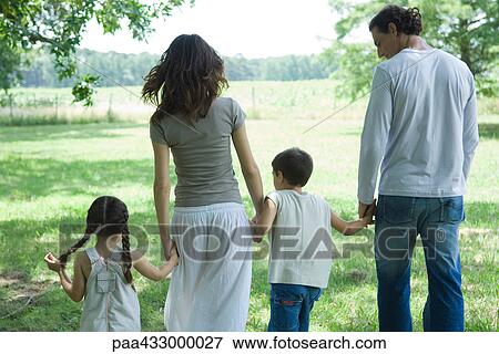 Family walking across lawn on a sunny day, rear view View Large Photo Image Stock Photo - Family walking across lawn on a sunny day, rear view. Fotosearch