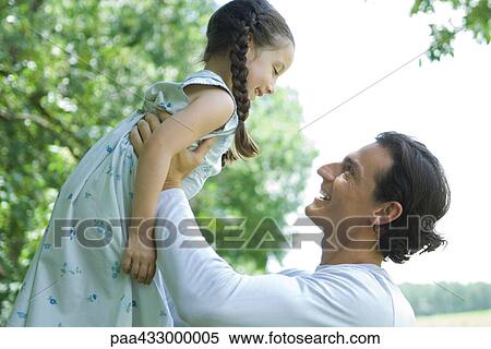 Man holding up daughter in air View Large Photo Image Stock Photography - Man holding up daughter in air. Fotosearch