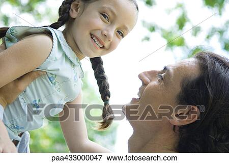 Man lifting up little girl, girl smiling at camera View Large Photo Image Stock Photo - Man lifting up little girl, girl smiling at camera. Fotosearch