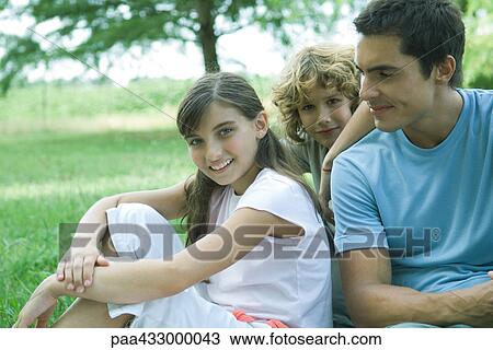 Man sitting outdoors with son and daughter View Large Photo Image Stock Image - Man sitting outdoors with son and daughter. Fotosearch