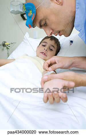 Boy lying in hospital bed, intern wearing mask on head removing adhesive tape from boy's arm View Large Photo Image Stock Image - Boy lying in hospital bed, intern wearing mask on head removing adhesive tape from boy's arm. Fotosearch