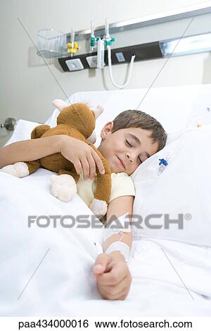 Boy sleeping in hospital bed sleeping, holding stuffed animal, smiling View Large Photo Image Stock Photograph - Boy sleeping in hospital bed sleeping, holding stuffed animal, smiling. Fotosearch
