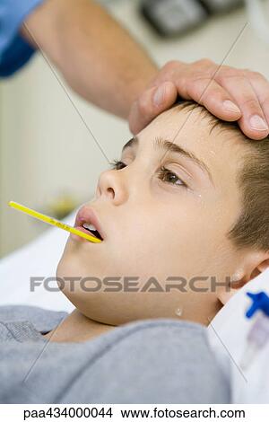 Boy with thermometer in mouth and man's hand on forehead View Large Photo Image Picture - Boy with thermometer in mouth and man's hand on forehead. Fotosearch