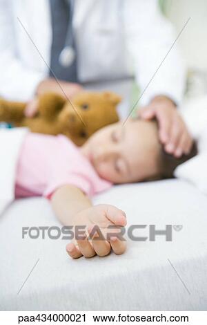 Girl sleeping in hospital bed, doctor's hand on forehead View Large Photo Image Stock Image - Girl sleeping in hospital bed, doctor's hand on forehead. Fotosearch