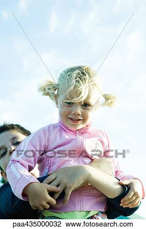Boy holding up little girl, low angle view View Large Photo Image Stock Image - Boy holding up little girl, low angle view. Fotosearch