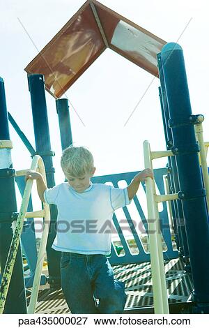 Boy on playground equipment, holding onto railing View Large Photo Image Stock Photo - Boy on playground equipment, holding onto railing. Fotosearch