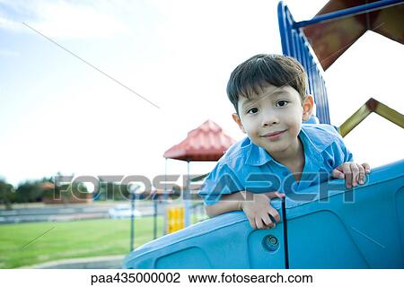 Boy on playground equipment, smiling at camera View Large Photo Image Stock Image - Boy on playground equipment, smiling at camera. Fotosearch