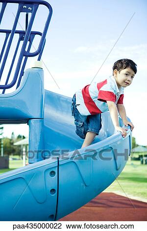 Boy on playground equipment, smiling, looking away View Large Photo Image Stock Image - Boy on playground equipment, smiling, looking away. Fotosearch